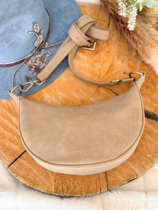 Beige handbag on a wooden surface with a blurred background