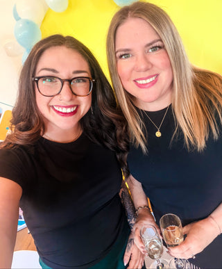 Two women posing for a selfie with colorful balloons in the background