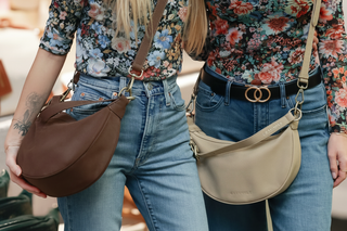 Two people wearing floral tops and jeans with handbags in a store setting.