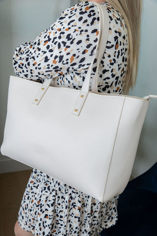 Person wearing a white tote bag with a leopard print outfit