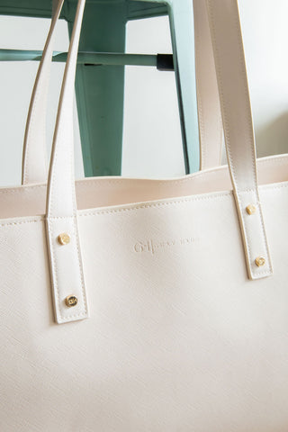 White tote bag with gold accents on a light background
