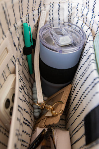 Blue tumbler with black base in a patterned bag