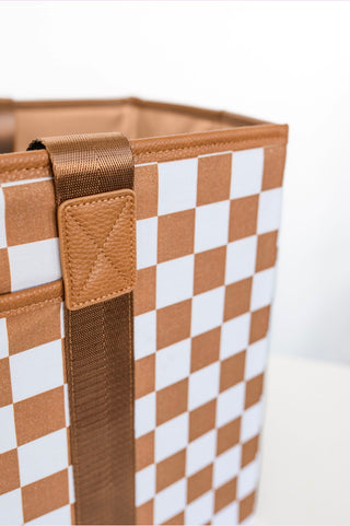 Checkered storage bin with brown straps on a white background